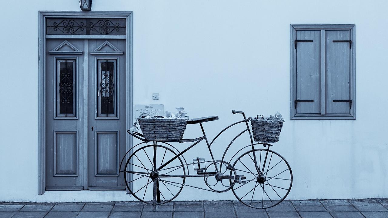 Bicycle in front of white wall with wooden door