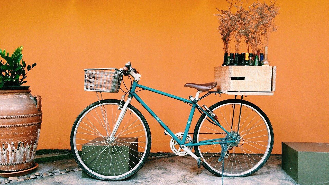 bicycle with basket on the back, against an orange wall
