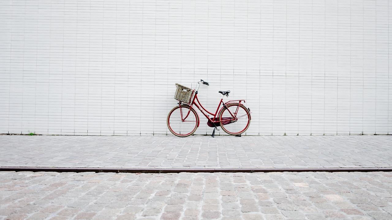 Red bicycle against white wall