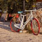 Red bicycle in front of stone wall