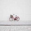 Red bicycle against white wall